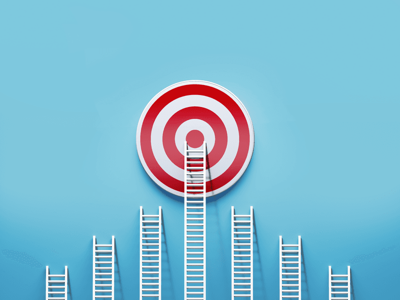 White ladders leaning on a red target on blue wall. Horizontal composition with copy space.