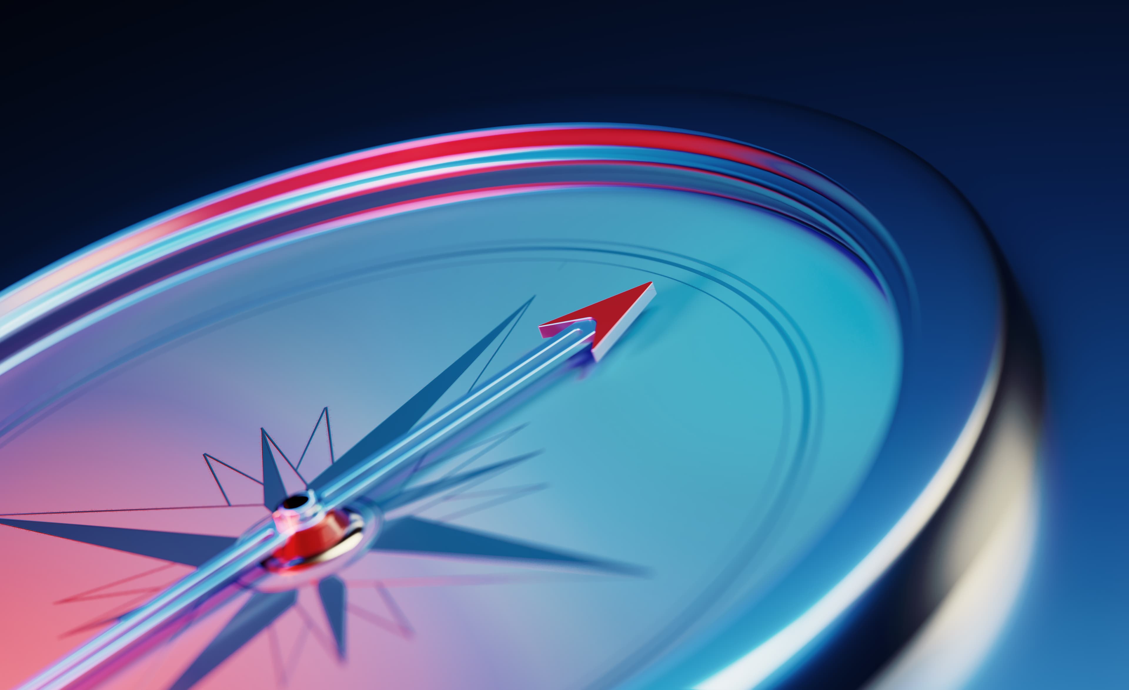 Compass sitting over dark blue metallic background. Horizontal composition with copy space.